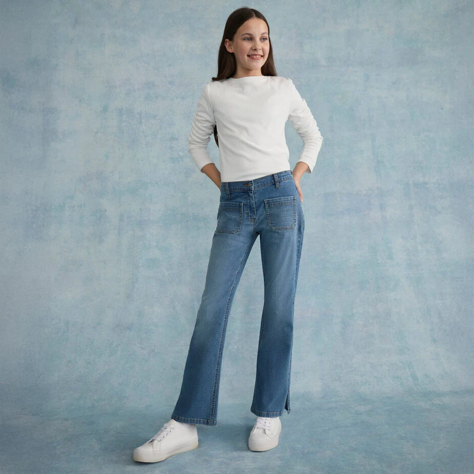 Fehér blúz skinny farmerrel és fehér cipőkkel párosítva.