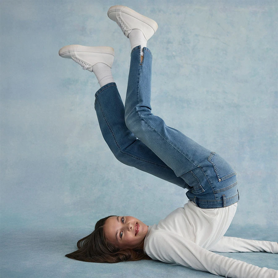 Fehér blúz skinny farmerrel és fehér cipőkkel párosítva.