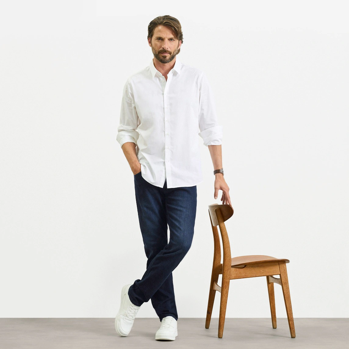 Fehér ing, sötét Slim Fit farmer és fehér sportcipő.