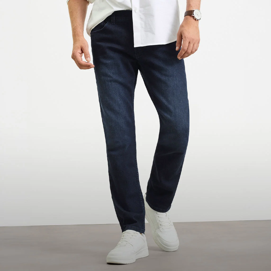 Fehér ing, sötét Slim Fit farmer és fehér sportcipő.